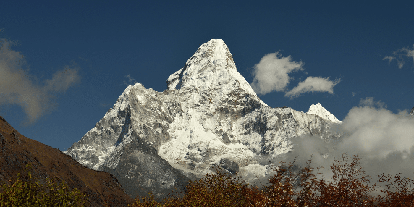 Aperçu impressionnant de l'Ama Dablam, l'une des montagnes emblématiques de l'Himalaya, avec un ciel dégagé. Cette image met en avant la beauté brute des montagnes népalaises et est idéale pour du contenu lié à la randonnée, l'alpinisme ou l'exploration des sommets.