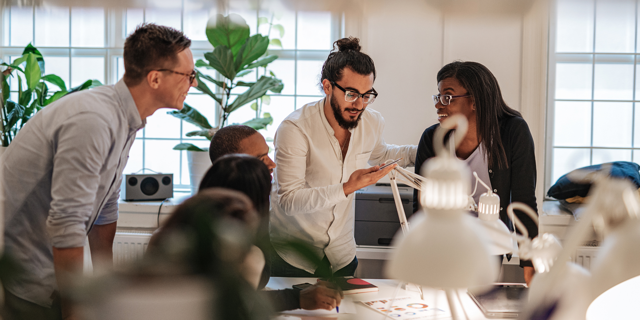 Équipe collaborative travaillant dans un bureau lumineux, illustrant les initiatives des start-up parisiennes axées sur l'innovation et le développement durable.