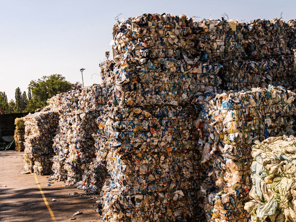 Tas de déchets plastiques compressés et empilés sur un site de recyclage.