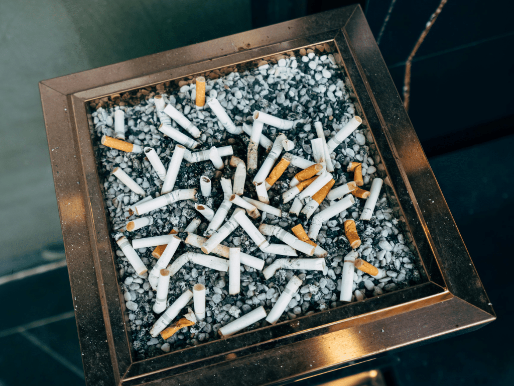 Gros plan d’un cendrier rempli de nombreux mégots de cigarettes usagés