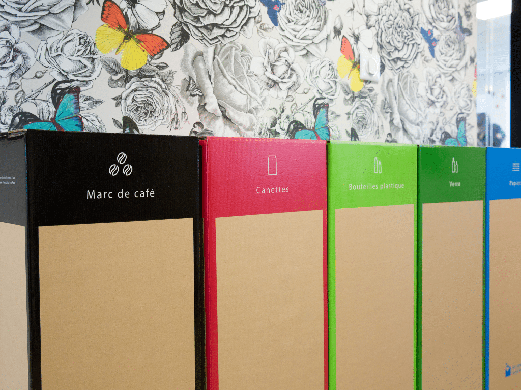 Rangée de bacs de tri sélectif aux couleurs vives, dont un pour le marc de café