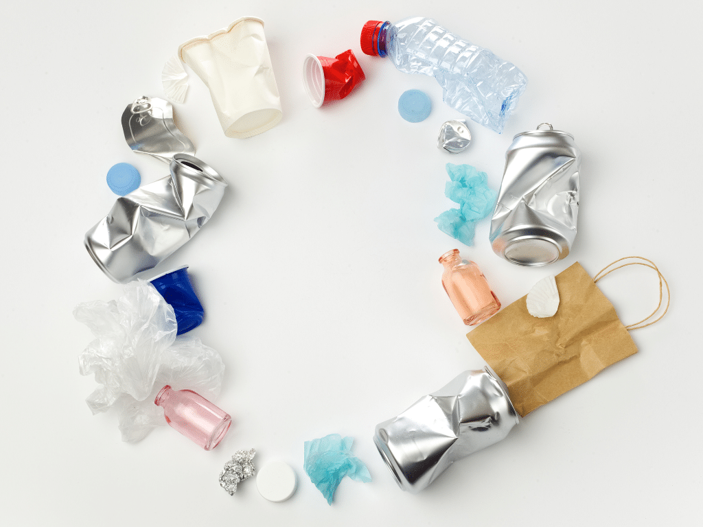 Tri sélectif en entreprise et gestion des déchets _ quelle différence pour les entreprises Composition circulaire d’emballages recyclables — canettes, bouteilles et bouchons en plastique — évoquant le tri sélectif