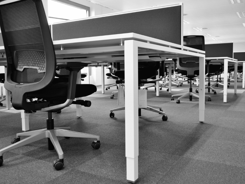 Des bureaux réutilisées dans une grande salle de réunion avec des chaises visibles