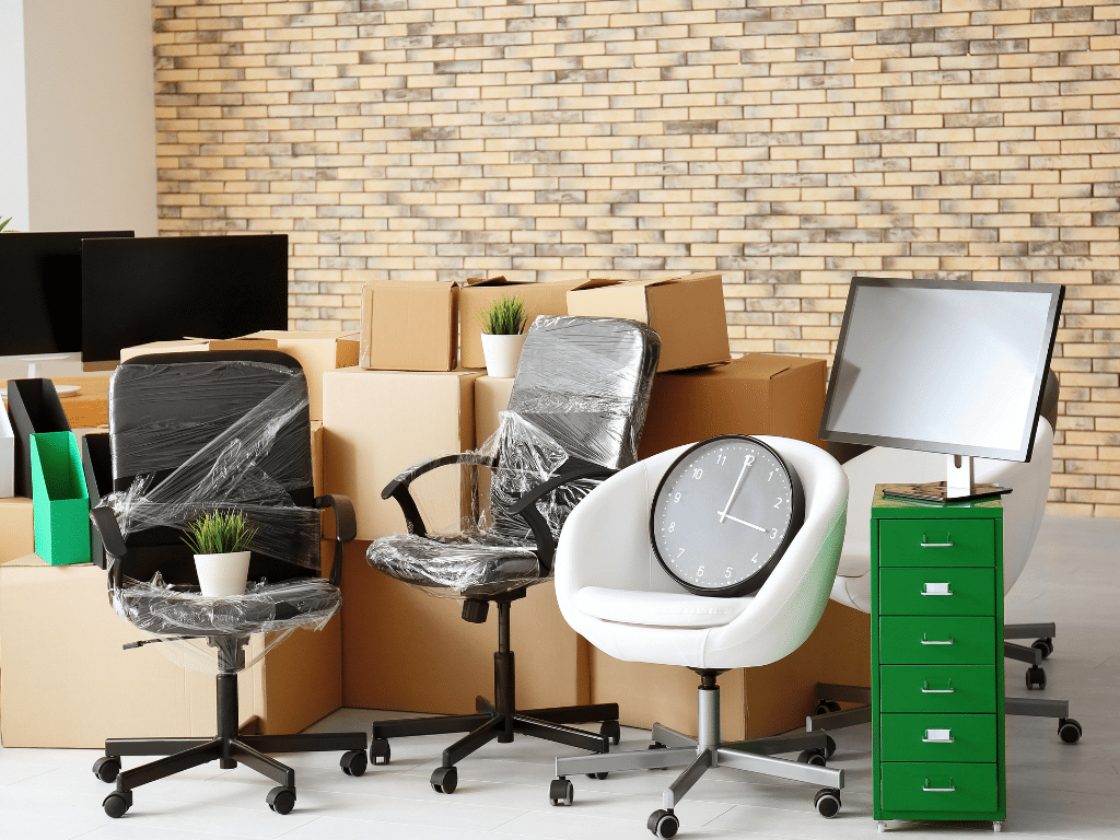 Bureau vide avec des chaises empilées, en noir et blanc, représentant un environnement de travail en cours de désinstallation ou de recyclage