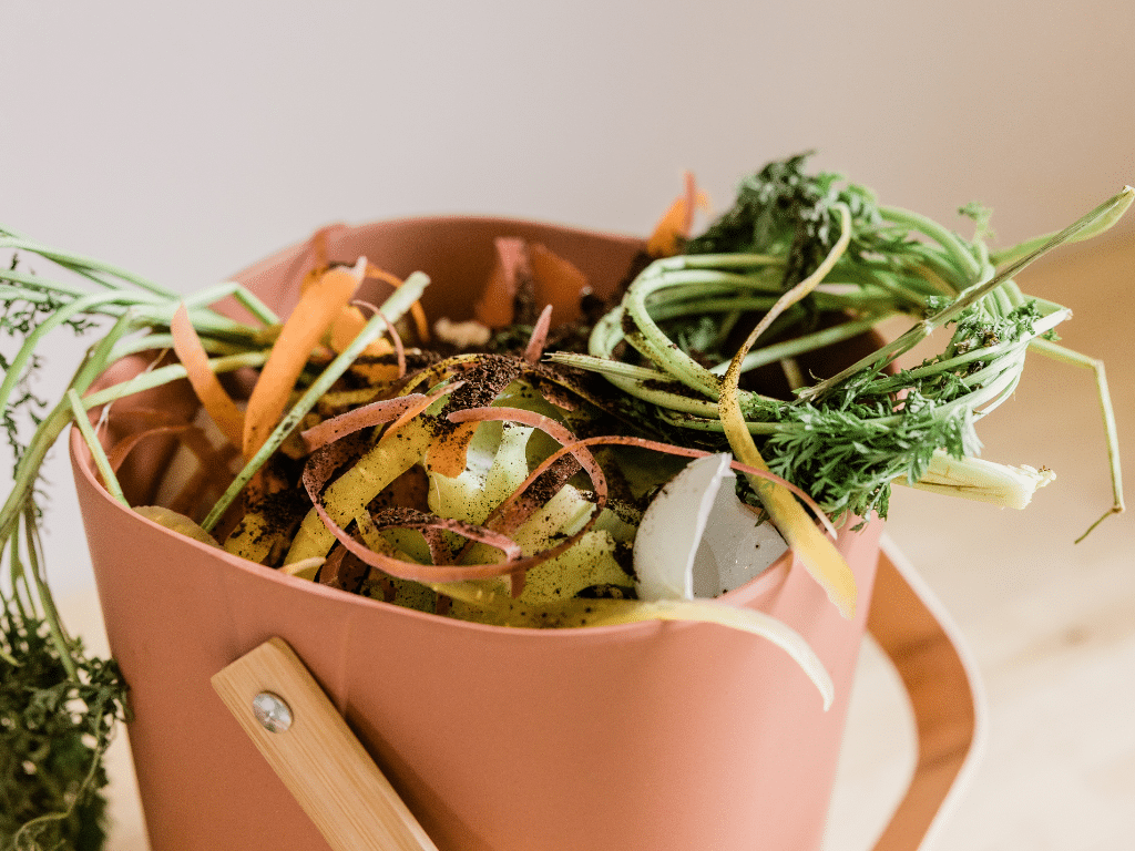 Poubelle de cuisine remplie d’épluchures de légumes et de restes alimentaires, illustrant le tri à la source des déchets organiques