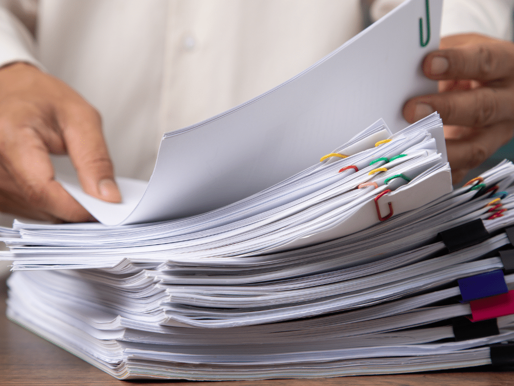 Une pile de documents papier, symbolisant la persistance du papier malgré les efforts de numérisation