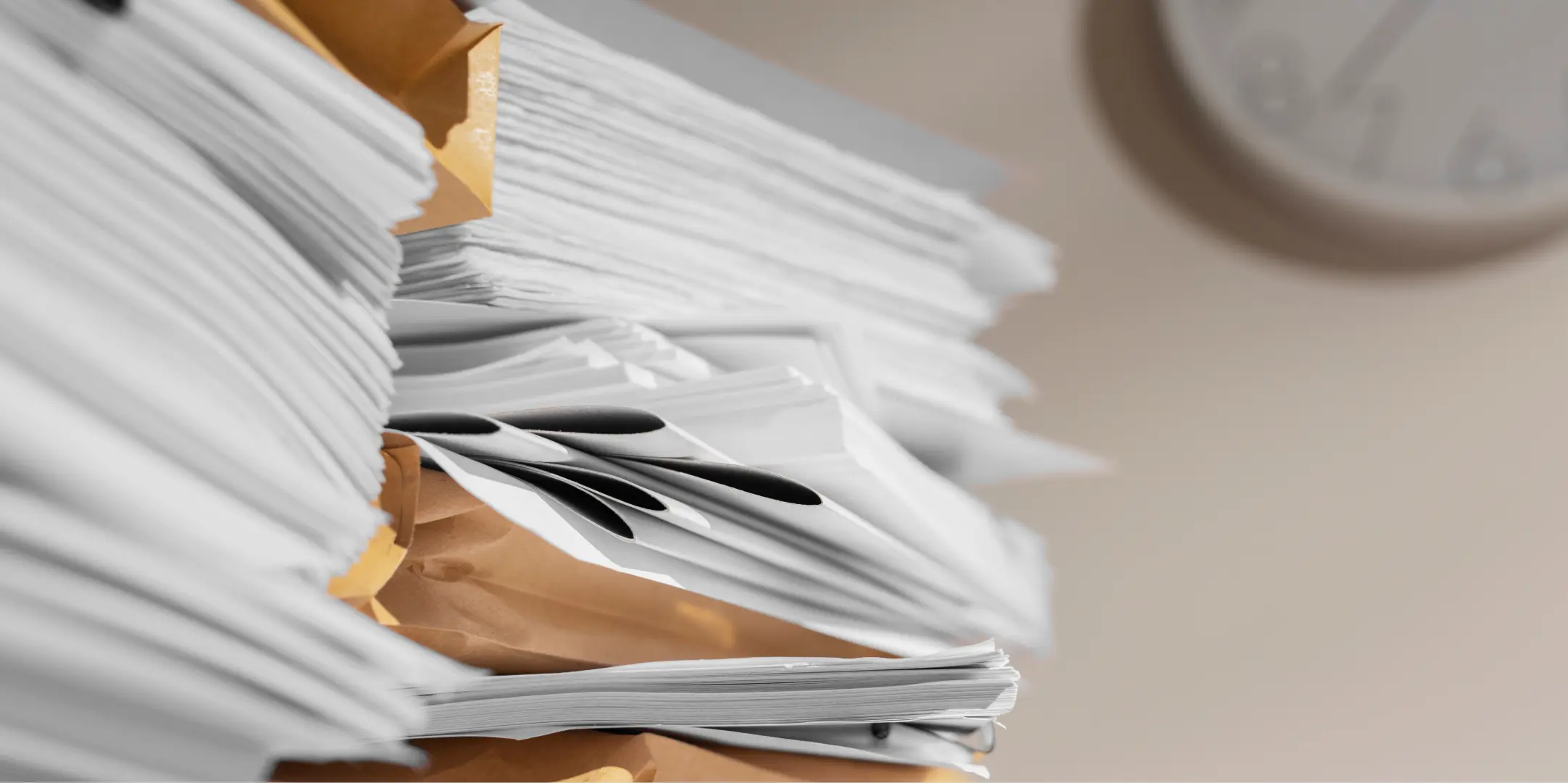 Pile de documents papier sur un bureau illustrant la consommation de papier en entreprise