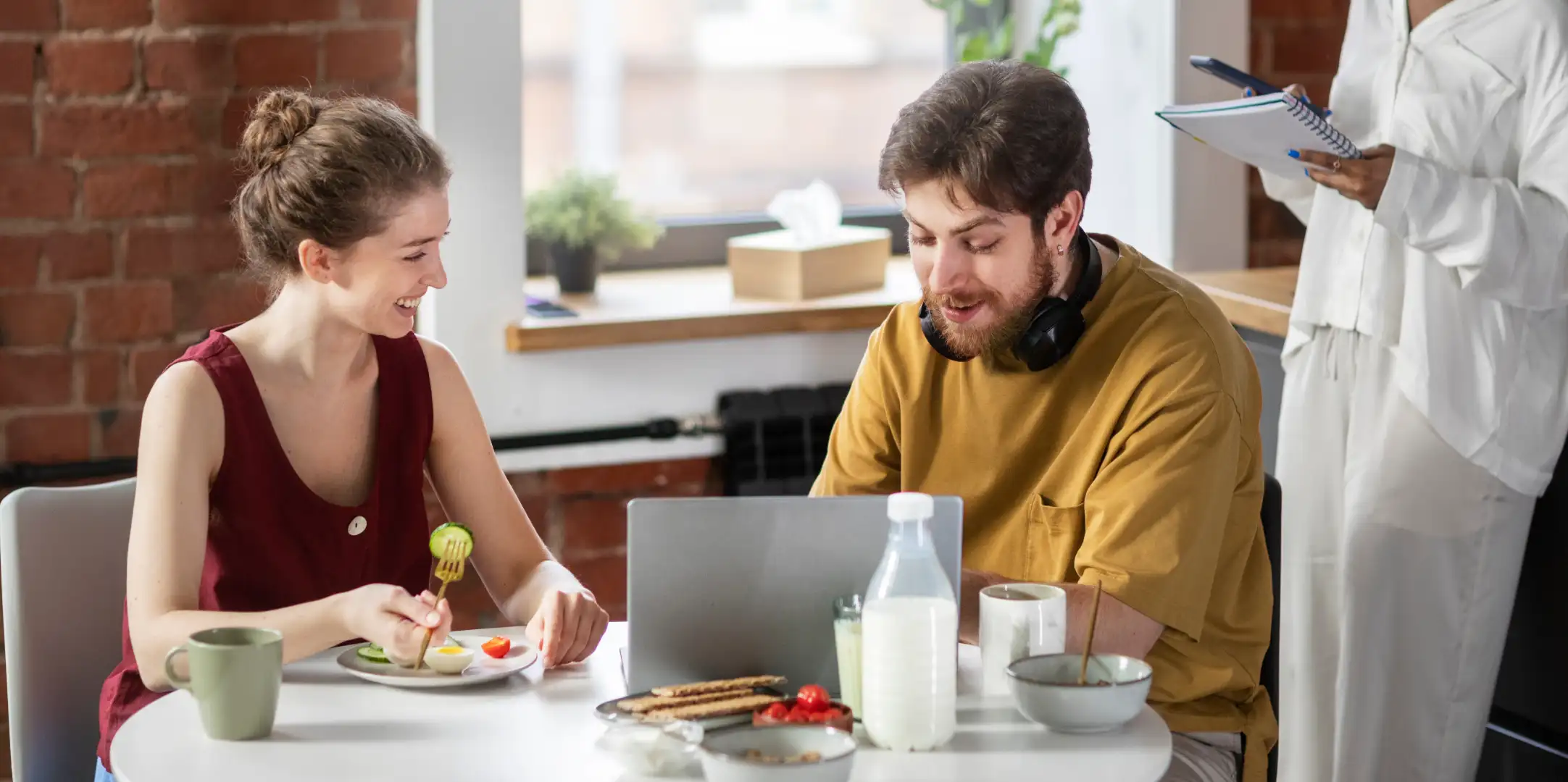Salariés partageant un repas pendant leur pause déjeuner au bureau avec des contenants réutilisables.